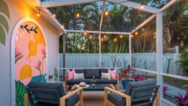 A cozy outdoor seating area with a cushioned sofa, two armchairs, and a coffee table.