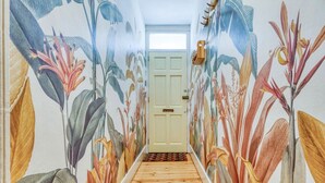 Un couloir doté d’un plancher en bois et dont les murs sont ornés d’illustrations botaniques.