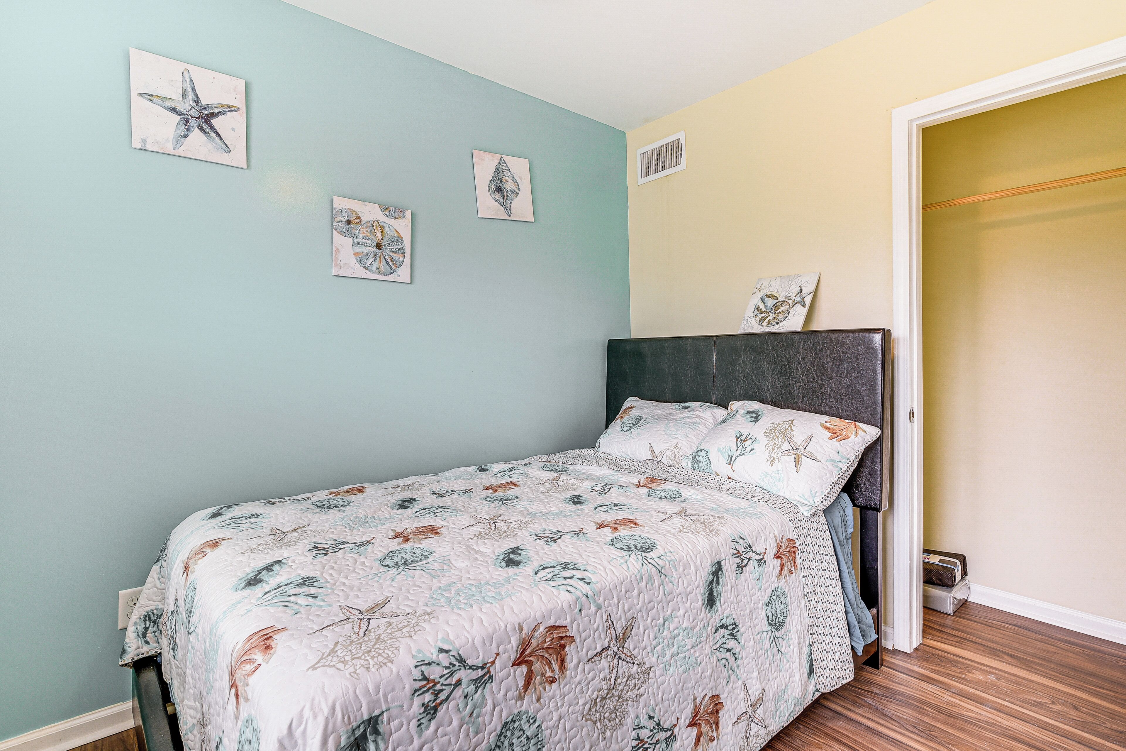 Une chambre à coucher comprenant un lit, une tête de lit et une porte donnant sur une autre pièce.