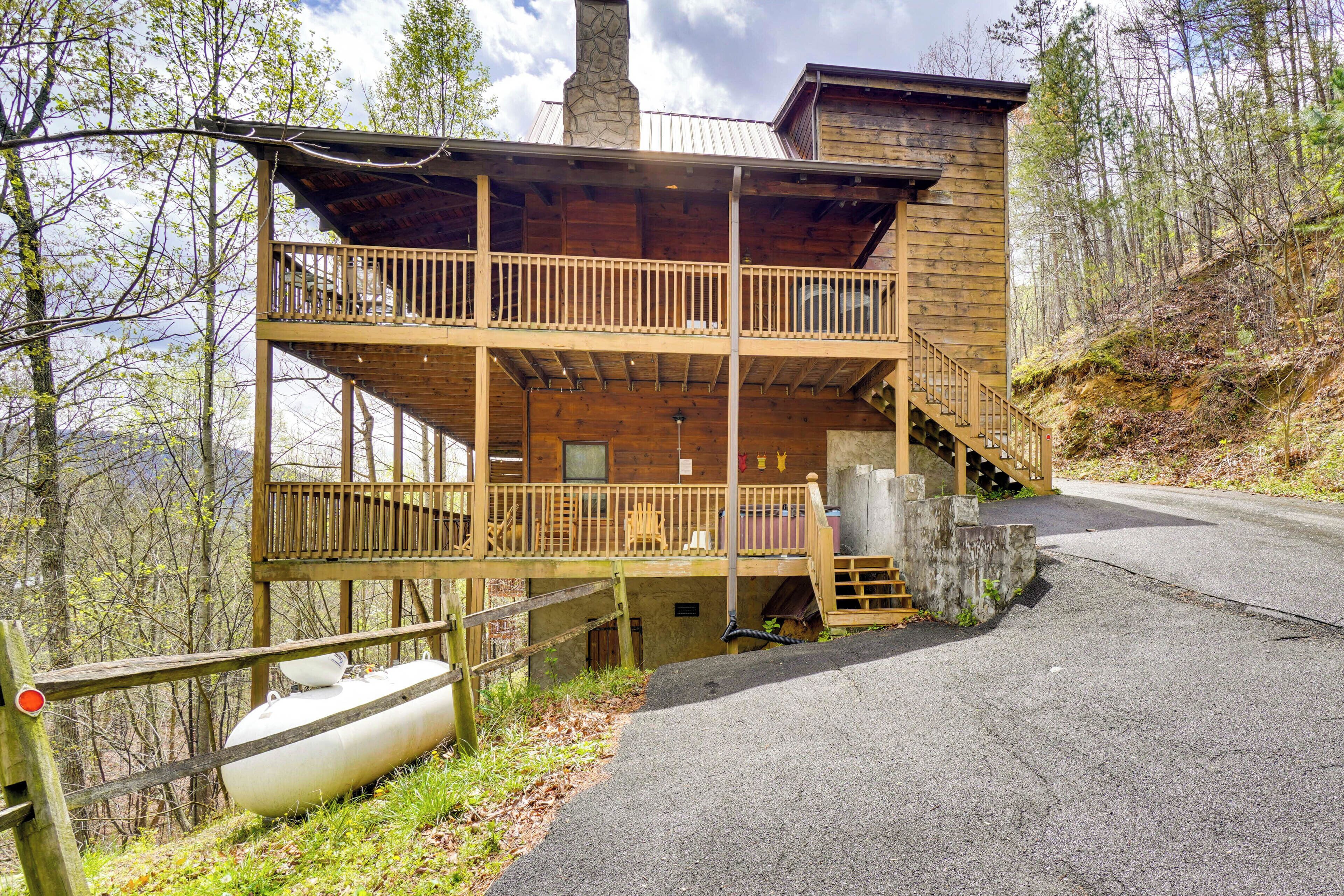 A two-story wooden cabin with a balcony, a staircase leading to the upper floor, and a boat docked outside.