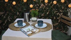A table set with two blue cups, a stainless steel coffee pot, a potted plant, and a magazine. - Enjoy Valencia. Studio located between Ruzafa and City of Arts and Sciences. (Valencia)