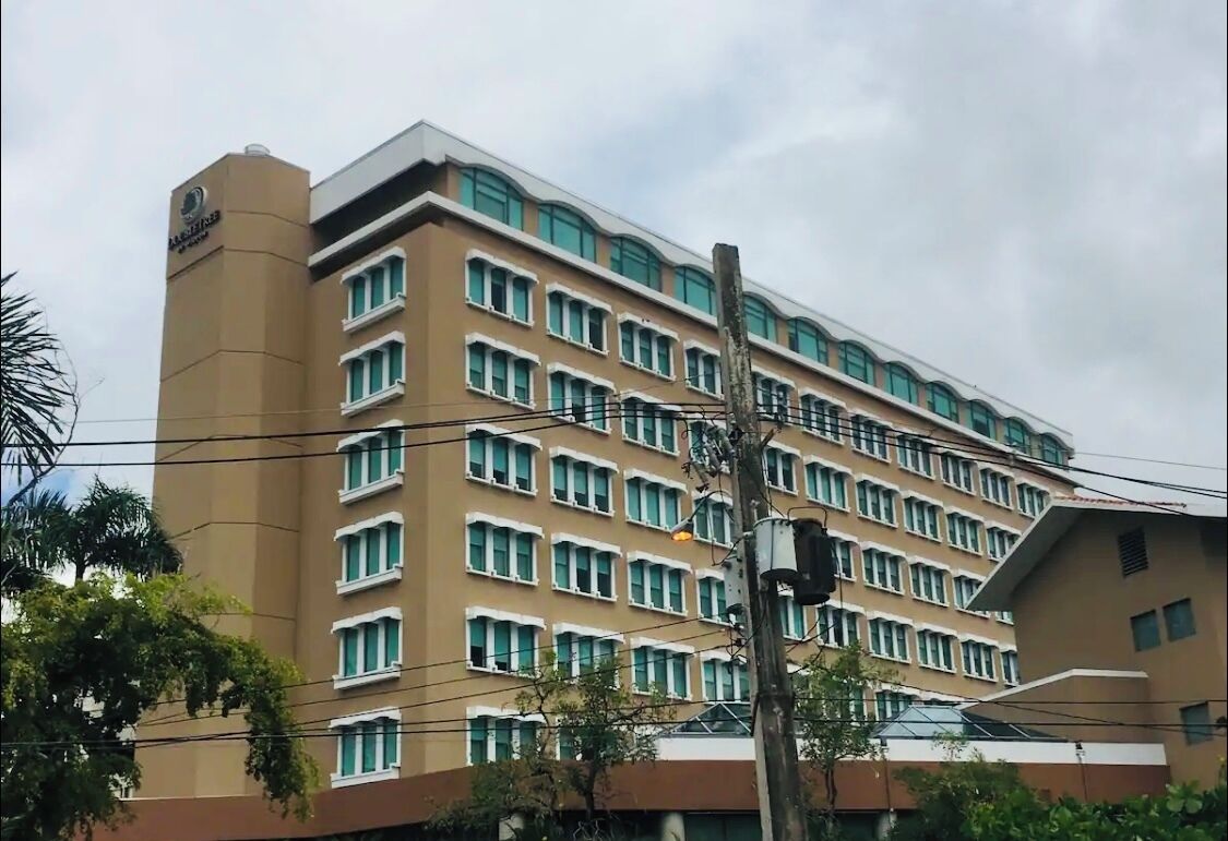 Un hôtel à plusieurs étages, doté d’une façade uniforme, de nombreuses fenêtres et d’une enseigne bien visible à l’angle.