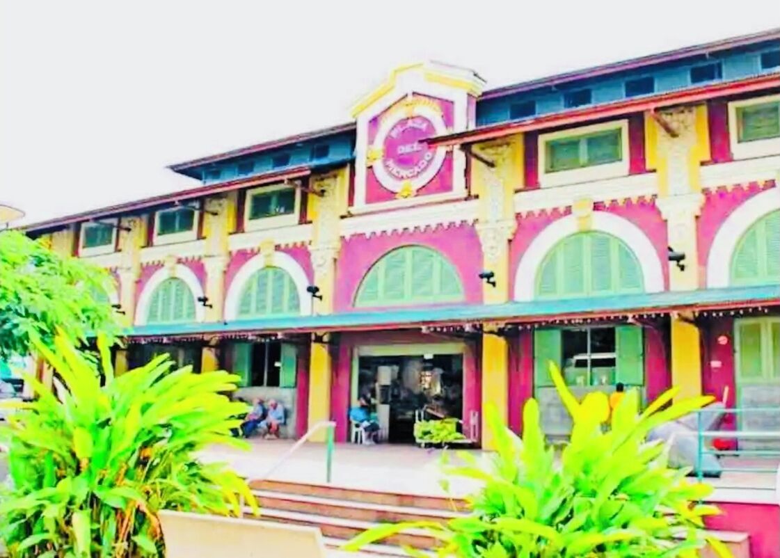 A colorful building with a prominent sign, large windows, and a covered entrance area.
