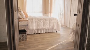 A bedroom with a bed, a bedside table, a lamp, and a window with curtains. - Breathtaking Mountain Views in La Union, El Salvador. Escape to serenity (Anamorós)