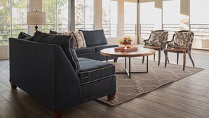 A spacious living room with a dark blue sofa, two armchairs, a coffee table, and a patterned rug. - Breathtaking Mountain Views in La Union, El Salvador. Escape to serenity (Anamorós)