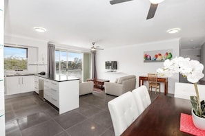 Un appartement moderne comprenant une cuisine, un coin repas et un salon.