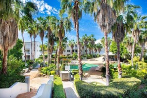 A resort with palm trees, a pool, and a pathway leading to the buildings. - Bridgewater Terrace (Brisbane)