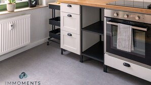 Een moderne keuken met een raam, koffiezetapparaat en fornuis.