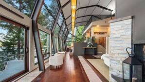 Un intérieur moderne avec de grandes fenêtres, un plancher en bois et un mur d’accent en pierre.
