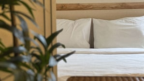 A bed with white linens, a wooden headboard, and a wooden bench. - Jnineguesthouse (Seoul)