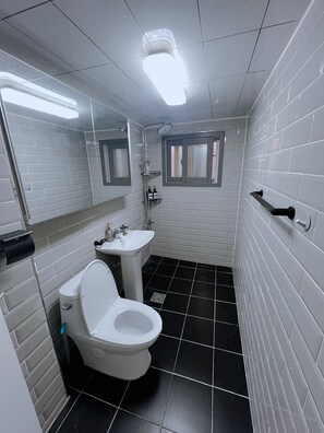 Ein Badezimmer mit Toilette, Waschbecken und Dusche.