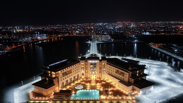 A large, well-lit hotel with a central courtyard and multiple swimming pools.