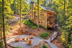 A cabin with a deck, a fire pit, and outdoor seating. - On the River with Arcade, Firepit & Pet Friendly! (Dahloenga)