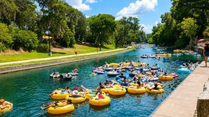 Un canal con gente flotando en tubos amarillos.