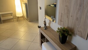 Ein Badezimmer mit einem Holzwaschtisch, einem Spiegel, einem Waschbecken und einer Topfpflanze.