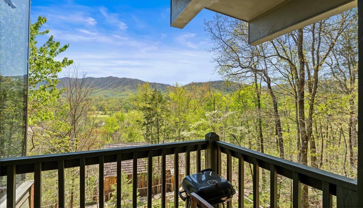 Ein Balkon mit Blick auf einen Wald und Berge.