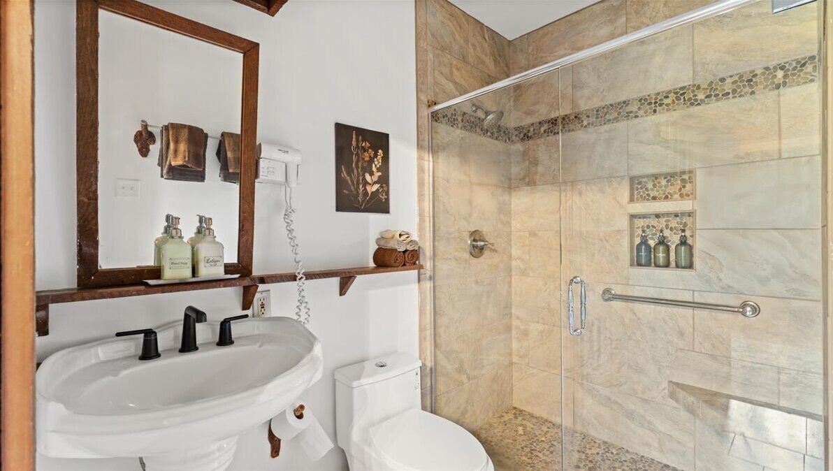 Een badkamer met een wastafel, toilet en douche.