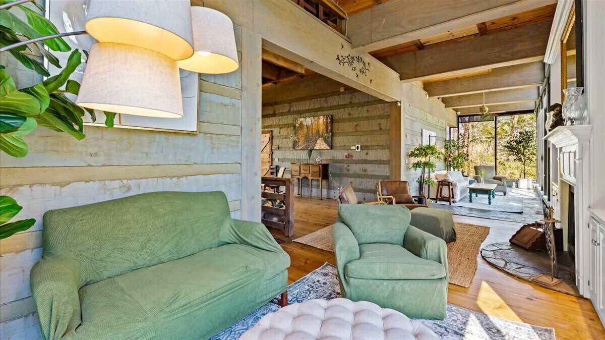 Una sala de estar acogedora con un sofá verde, un sillón a juego y una chimenea.