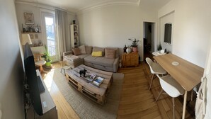 Un salon comprenant un canapé, une table basse et un coin repas avec une table et des chaises.