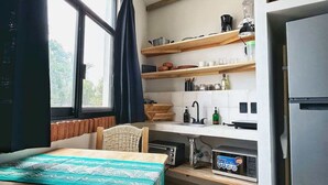 Una cocina compacta con comedor, microondas integrado y refrigerador.