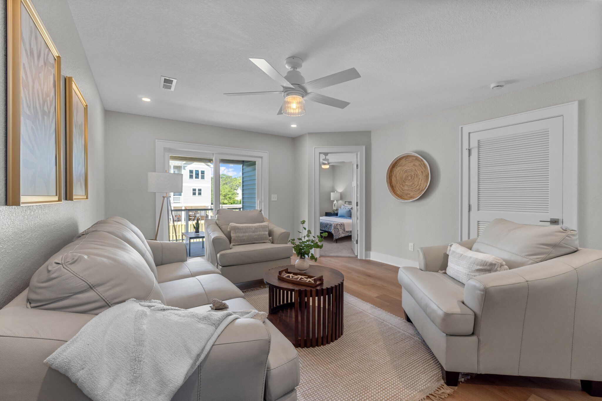 A spacious living room with a ceiling fan, a round coffee table, and two sofas.