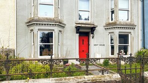 A two-story house with a red door and multiple windows, labeled "KENT HOUSE." - Escape to our pet-friendly haven nestled in the heart of Carmarthen. (Carmarthen)