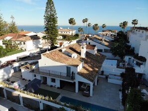 A residential area with white buildings, a swimming pool, and a view of the sea. - Moderna Villa con Piscina, a 30 Metros de la Playa, en la Mejor Zona de Marbella (Marbella)