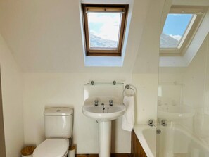 A compact bathroom with a skylight, a toilet, a sink, and a glass-enclosed shower. - Avoca House in the village of Onich (Fort William)