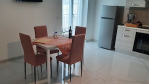 A modern kitchen with a dining area, a flat-screen TV mounted on the wall, and a large window with curtains. - In the Green of Irpinia locality Montemarano (Avellino) stands Tenuta Casa Arsa. (Casa Arsa)