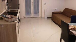 A modern kitchen with a sink, stove, and dining area with a table and chairs. - In the Green of Irpinia locality Montemarano (Avellino) stands Tenuta Casa Arsa. (Casa Arsa)