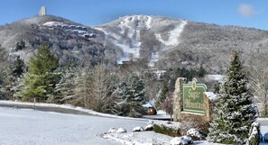 Eine verschneite Landschaft mit einem Berg und einem Schild für Sugar Mountain.