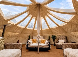 A tent-like interior with a bed, two chairs, and a central pole. - The Riverside Retreat (GLOUCESTERSHIRE)