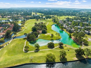 Ein Golfplatz mit einem See, umgeben von Wohngebieten.