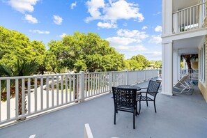 A balcony with a white railing, a round table, and two chairs. - Baytowne Wharf Condo-Large Private Balcony-Beach (Miramar Beach)