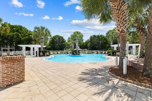 A swimming pool with a brick border, surrounded by palm trees and a white fence. - Baytowne Wharf Condo-Large Private Balcony-Beach (Miramar Beach)