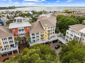 Una zona residencial costera con edificios de varios pisos, balcones y un puerto deportivo al fondo.