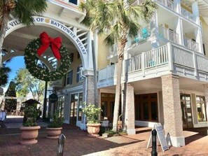 A hotel entrance with a porch, palm trees, and a wreath.