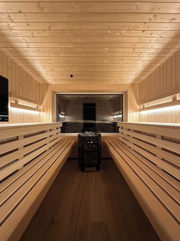 Un sauna con bancos de madera y un pilar central.