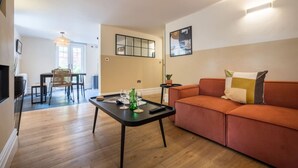 A living room with a sofa, a coffee table, and a dining area with a table and chairs. - Leven  The  Bowering (Cumbria)