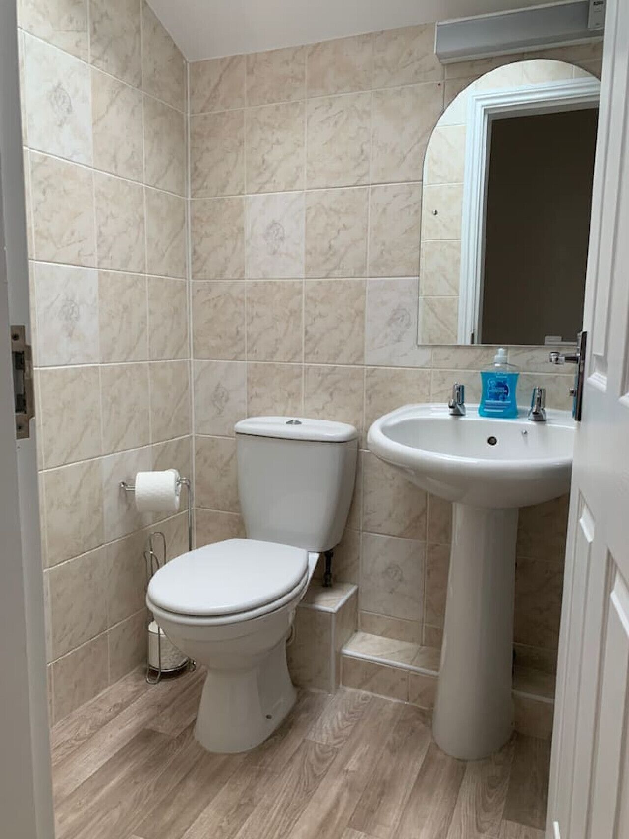Une petite salle de bain avec des toilettes, un lavabo et un miroir.