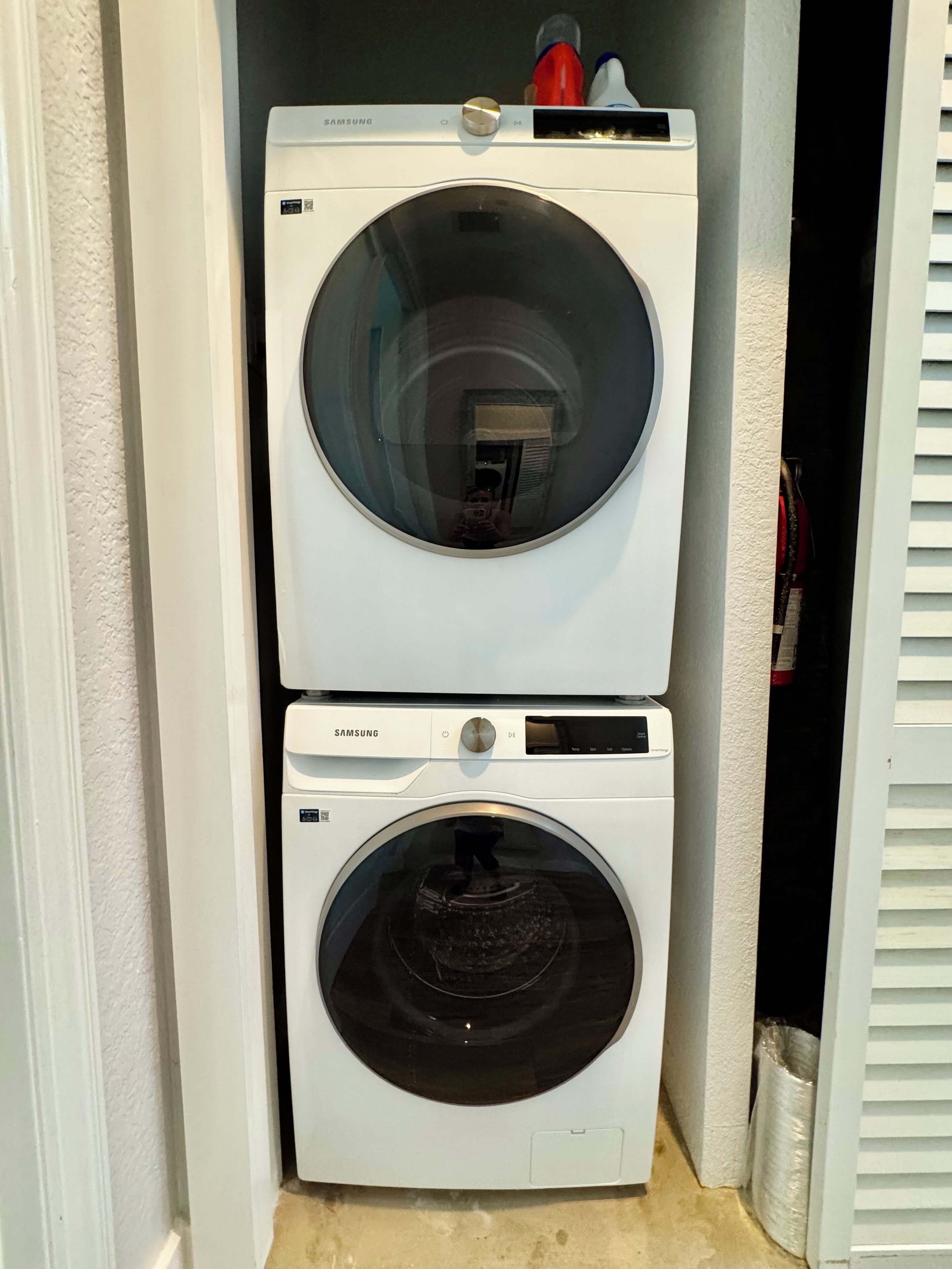 Une machine à laver et un sèche-linge Samsung à chargement frontal, superposés dans une buanderie.