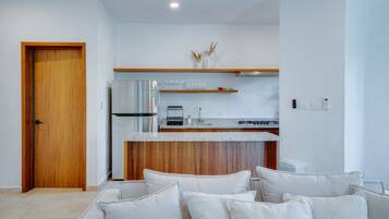 Une cuisine moderne avec une porte en bois, un réfrigérateur encastré et un plan de travail doté d’un évier et d’une cuisinière.