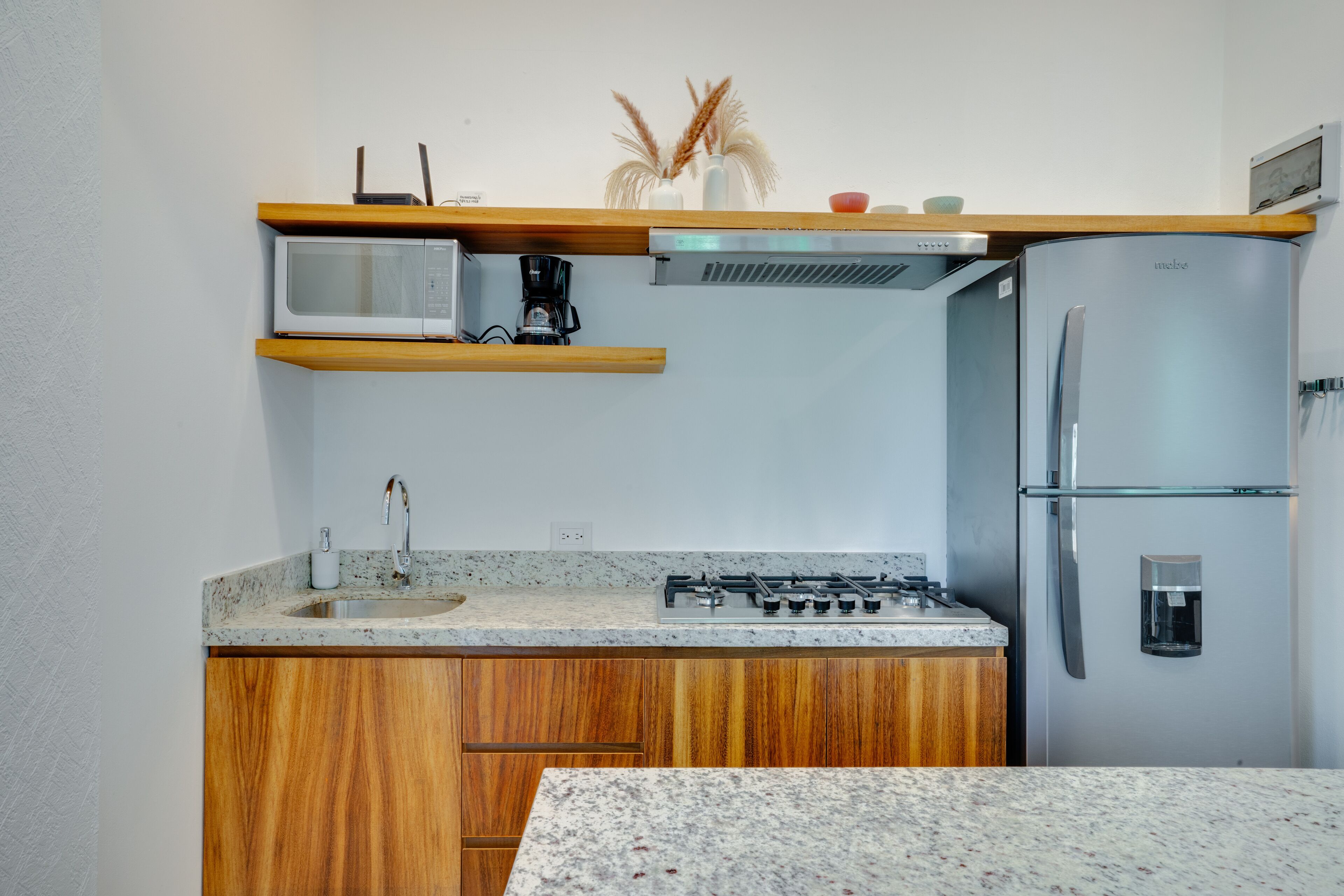 A compact kitchen with a microwave, stove, and refrigerator.