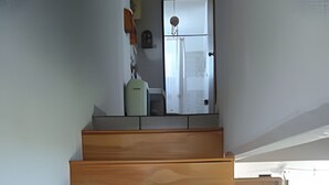 Eine Holztreppe führt zu einer Aussichtsplattform mit Blick nach draußen.