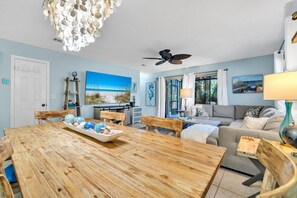 Relax in this inviting living room with a comfortable sofa, dining table, and artwork.