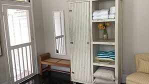 A room with a white wardrobe, a bench, and a chair. - Downtown Nassau Oasis: Unit 1 (Nassau)