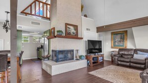 A spacious living area with a fireplace, a television, and a comfortable seating area.