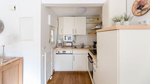 A compact kitchen with white cabinets, a microwave, a coffee maker, and a sink. - Ferienhaus am Waldrand Direkt am Sauerländer Höhenflug (Eslohe (Sauerland))
