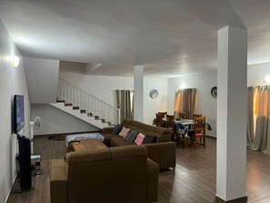 Relax in this inviting living area with a sofa set, dining table, and flat-screen TV.