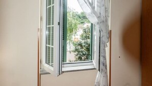 Una habitación con ventana, una silla y una puerta.
